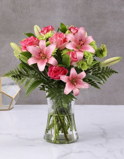 Lush Pink Lilies And Cerise Roses In A Vase